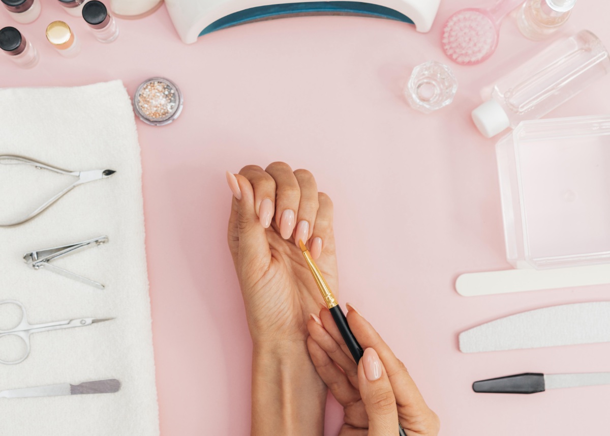 Professionelle Nageldesign-Arbeitsumgebung mit Werkzeugen und gepflegten Händen